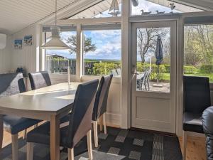 a dining room with a table and chairs and a window at 4 person holiday home in Rudkøbing in Spodsbjerg