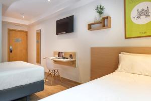 a hotel room with two beds and a desk at Rooms Ciencias in Valencia +60 photos