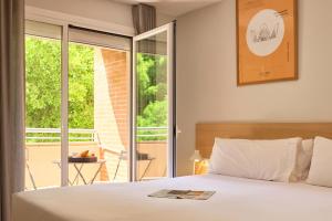 a bedroom with a white bed and a balcony at Rooms Ciencias in Valencia