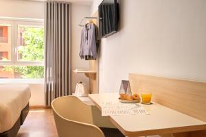 a hotel room with a bed and a table with a drink at Rooms Ciencias in Valencia