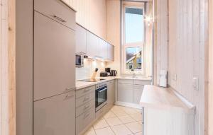 a kitchen with white cabinets and a window at Nice Home In Rechlin With Sauna in Rechlin