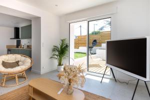 a living room with a large flat screen tv at Villa Alma in Seignosse