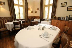 un comedor con 2 mesas y sillas con mantel blanco en Hotel & Restaurant The House, en Sofía