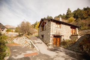 een stenen huis met een trap daarheen bij R de rural - Borda del Mollà in Encamp