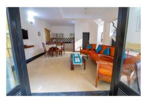 a living room with a couch and a table at Lagoon Villa in Old Goa