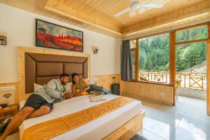 カソルにあるThe Social Stays Kasol formerly ArtBuzzの寝室のベッドに横たわる男女