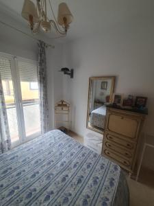 a bedroom with a bed and a dresser and a mirror at Bogavante Costa Ballena in Rota