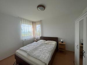sypialnia z łóżkiem z białą pościelą i oknem w obiekcie Summer Vibe Siofok 2 Ground floor w Siófoku