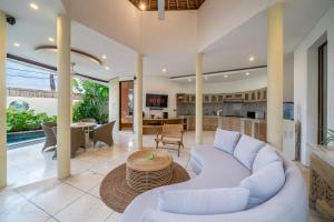 a living room with a white couch and a table at Villa Coccoos II Spacious 2BR Pererenan Canggu in Tumbak Bayuh
