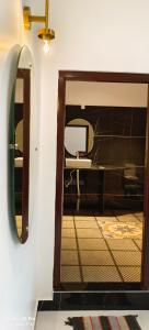 a mirror in a room with a table and a chair at Saanvi Farmhouse in Hampi