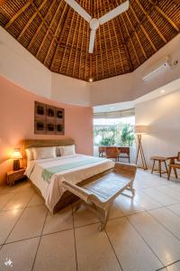 a bedroom with a large bed with a wooden ceiling at Villa Coccoos II Spacious 2BR Pererenan Canggu in Tumbak Bayuh