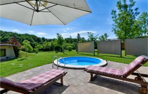 a swimming pool with two chairs and an umbrella at Amazing Home In Lopatinec With Jacuzzi in Lopatinec +28 photos