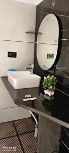 a bathroom with a white sink and a mirror at Saanvi Farmhouse in Hampi
