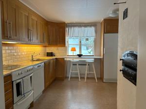 a kitchen with wooden cabinets and a counter top at Prästgården 303 Västra Tunhem in Västra Tunhem