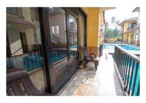 a balcony with a bench next to a swimming pool at Lagoon Villa in Old Goa