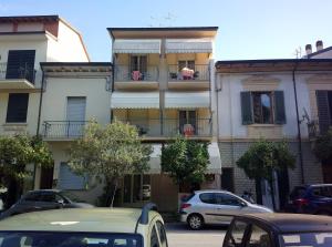 a building with cars parked in front of it at Hotel Delhy in Viareggio