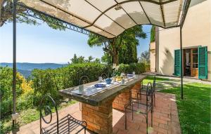 Un patio con una mesa y sillas bajo una sombrilla. en Borgo Elisa, en Cortona