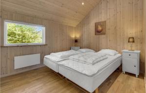 a bedroom with a large bed with a window at Holiday Home Bæverstien V in Marielyst +14 photos