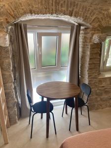 a table and chairs in a room with a window at studio apartment Vicelic in Dubrovnik
