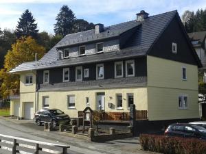 a large house with a black roof at Fewo In Schustes in Willingen
