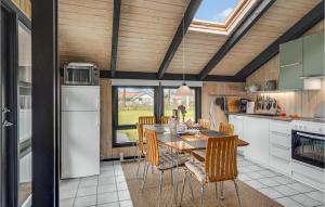 a kitchen and dining room with a table and chairs at Holiday Home Syrenvej Tranekær I in Skattebølle