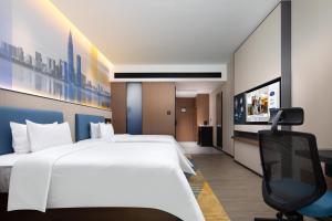 Postel nebo postele na pokoji v ubytování Hampton by Hilton Shenzhen Longgang Yonghu