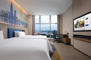 Postel nebo postele na pokoji v ubytování Hampton by Hilton Shenzhen Longgang Yonghu
