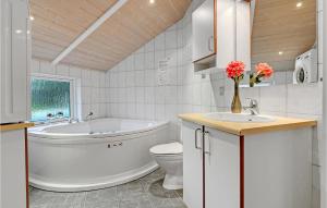 a bathroom with a tub and a toilet and a sink at Holiday Home Toften Hadsund V in Nørre Hurup