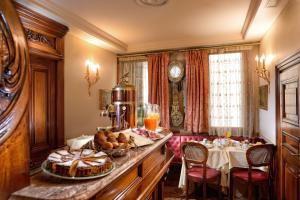 uma sala de pequenos-almoços com uma mesa com um prato de comida em Bellevue Luxury Rooms - San Marco Luxury em Veneza
