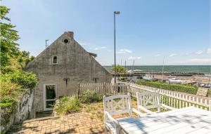 een oud stenen gebouw met een wit hek en stoelen bij Holiday Home Vang Hasle Ii in Hasle