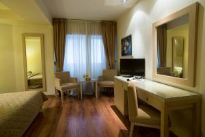 a hotel room with a desk and a bedroom at Davitel - Tobacco Hotel in Thessaloniki