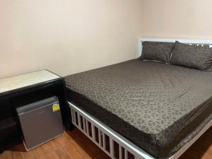 a small bed in a room with a table at Mong Do Lay Home Stay in Ban Ao Makham