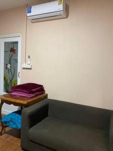 a living room with a couch and a air conditioner at Mong Do Lay Home Stay in Ban Ao Makham