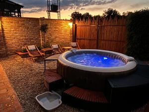 a hot tub in a yard with chairs and a fence at Kuća za odmor Erdelji in Vardarac