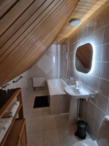 a bathroom with a sink and a bath tub at Nidos burė in Nida +27 photos