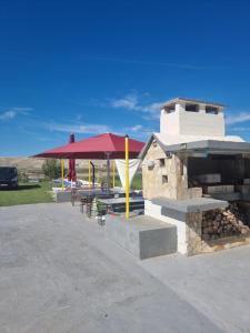 a picnic area with a table and a stone oven at APARTMANI ALEN in Dinjiška