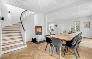 a dining room with a table and chairs and a staircase at Amazing Home In Væggerløse With Sauna in Marielyst