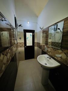 a bathroom with a sink and a shower and a mirror at Gagana Vila 01 in Kandy