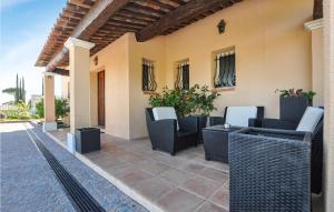 a patio with wicker chairs and tables on a house at Stunning Home In L Adrets De L'esterel in Les Adrets de l'Esterel +46 photos