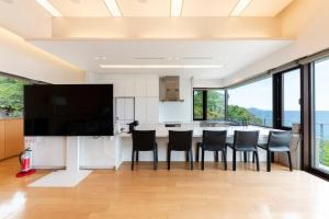 a kitchen with a table with chairs and a television at Villa Orchid in Otaru