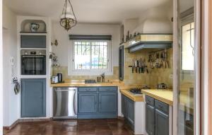 a kitchen with blue cabinets and a window at Stunning Home In L Adrets De L'esterel in Les Adrets de l'Esterel