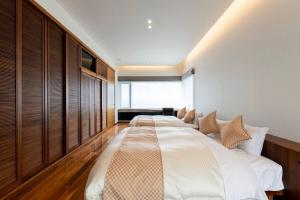 two beds in a bedroom with wooden paneling at Villa Orchid in Otaru +92 photos