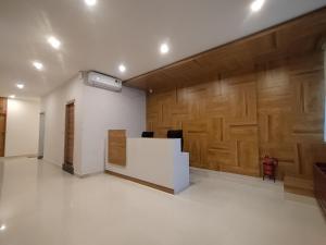 an office with a white desk and wooden wall at Zing Rooms by GuestHouse Suites in Bengaluru