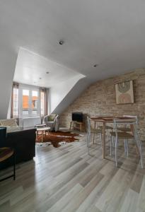 ヴィシーにあるLe Doumer - Charmant 2 pièces en Centre Villeのレンガの壁、テーブル付きのリビングルーム