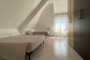 a white room with two beds and a window at Sibilla Tiburtina House Attico Roma con parcheggio in Rome