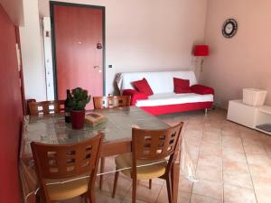 Una sala de estar con una mesa y sillas y un sofá. en FraDa's Home, en Quartu SantʼElena