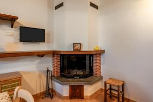 Una sala de estar con chimenea y televisión. en Casa Albereta, en Bagni di Lucca