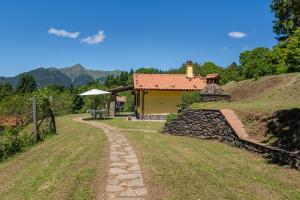 una casa con un camino de piedra junto a un edificio en Casa Albereta, en Bagni di Lucca