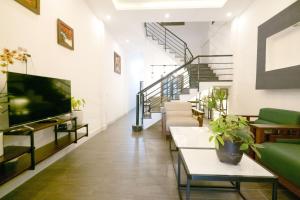 a living room with stairs and a flat screen tv at Fa's House Hue in Thôn Kim Long (1)