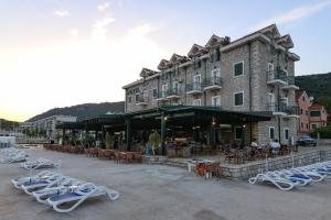 a large building with chairs and tables and a building at Hotel RR in Herceg-Novi